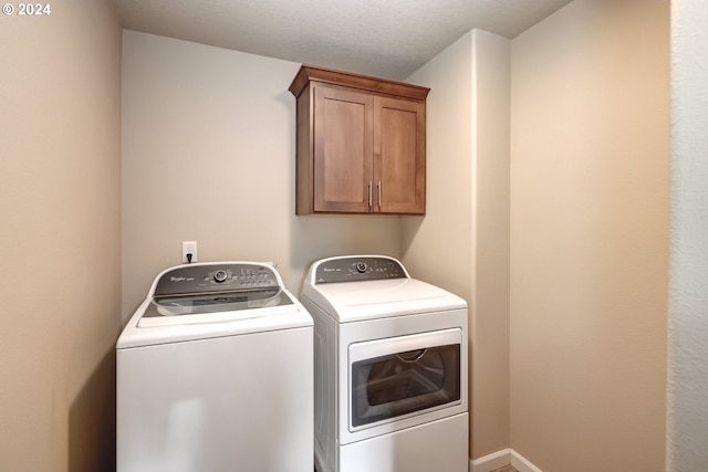 laundry room featuring cabinets and washing machine and clothes dryer