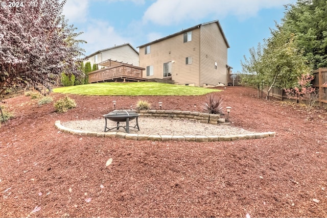 back of property with a yard and a fire pit