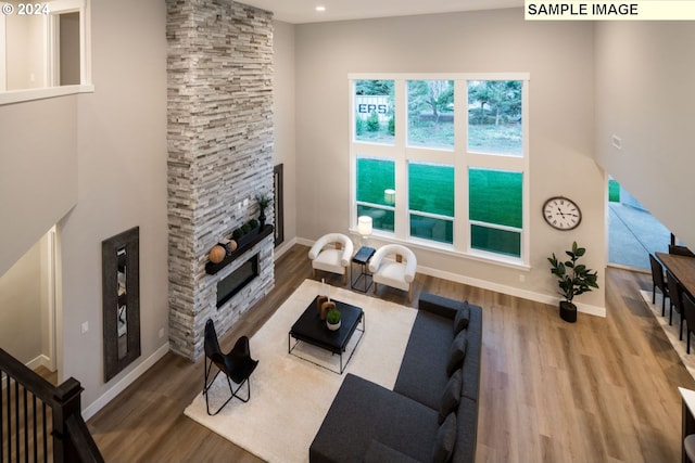 living room featuring a stone fireplace and dark hardwood / wood-style flooring