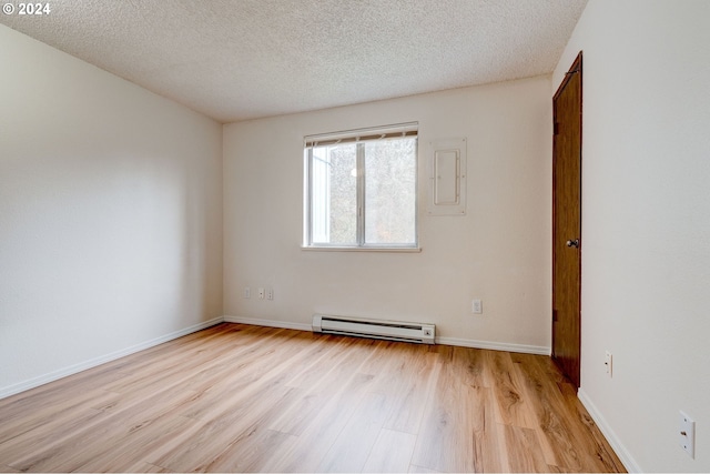 spare room with light wood-type flooring, a textured ceiling, and a baseboard radiator