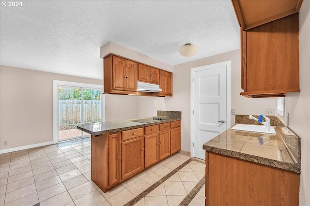 kitchen featuring light tile patterned floors, a textured ceiling, sink, and kitchen peninsula