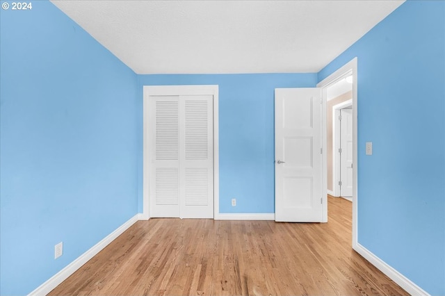 unfurnished bedroom featuring a closet and light hardwood / wood-style floors