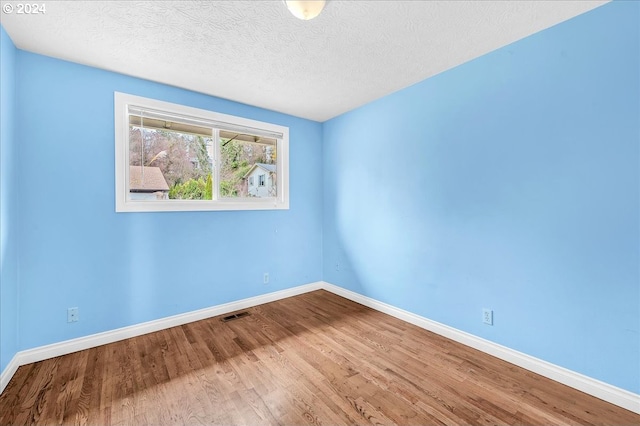 empty room featuring hardwood / wood-style floors and a textured ceiling