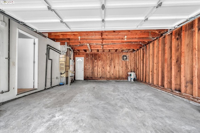 garage featuring wood walls and water heater