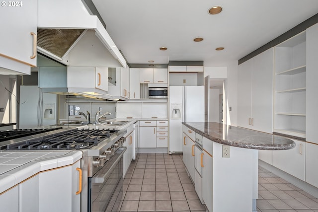 kitchen featuring extractor fan, appliances with stainless steel finishes, light tile patterned floors, and white cabinets