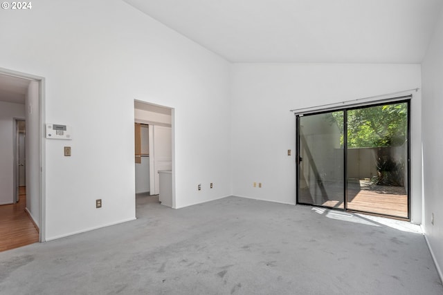 unfurnished room featuring light colored carpet and high vaulted ceiling