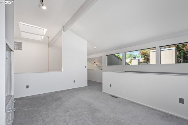 unfurnished room with vaulted ceiling with beams, carpet floors, and a water view