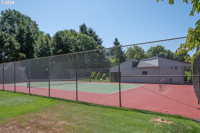 view of tennis court with a yard