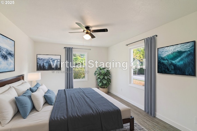 bedroom featuring ceiling fan, dark wood-type flooring, and a textured ceiling