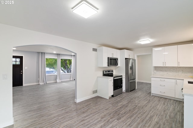 7331 SW Oak St, Tigard, OR 97223 - kitchen featuring appliances with stainless steel finishes, arched walkways, light wood-style floors, and light countertops