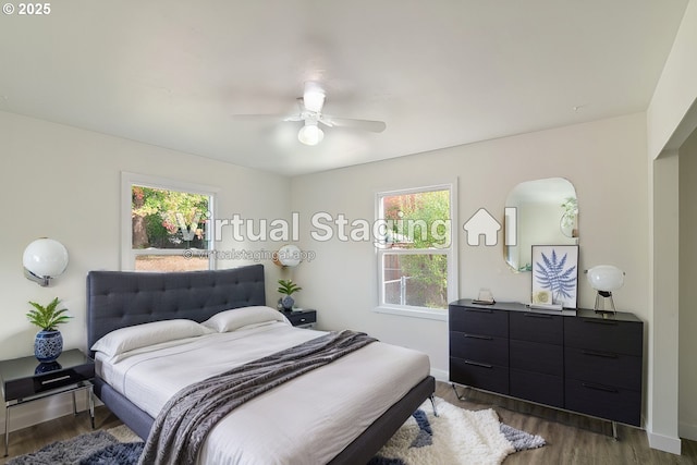 bedroom featuring dark wood-type flooring, ceiling fan, and multiple windows