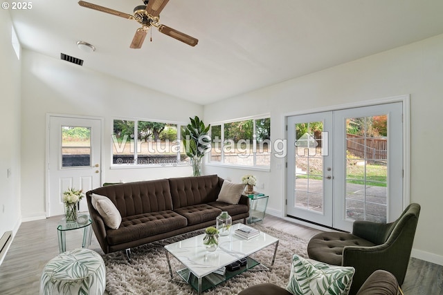 living room featuring a baseboard radiator, french doors, hardwood / wood-style floors, lofted ceiling, and ceiling fan