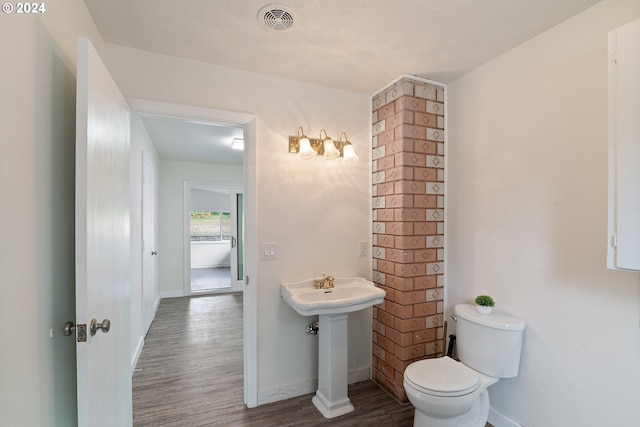 bathroom with toilet and wood-type flooring