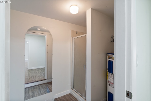 bathroom featuring walk in shower, hardwood / wood-style floors, and electric water heater