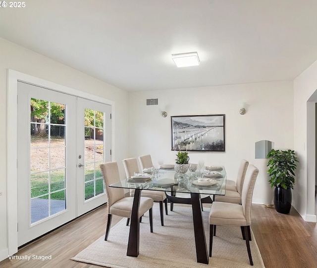 dining area with light hardwood / wood-style floors and french doors