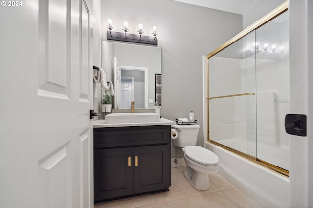 full bathroom featuring combined bath / shower with glass door, vanity, tile patterned floors, and toilet