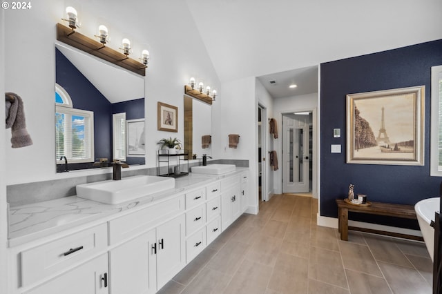 bathroom with tile patterned flooring, vanity, and lofted ceiling