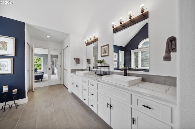 bathroom featuring vanity, tile patterned floors, and lofted ceiling