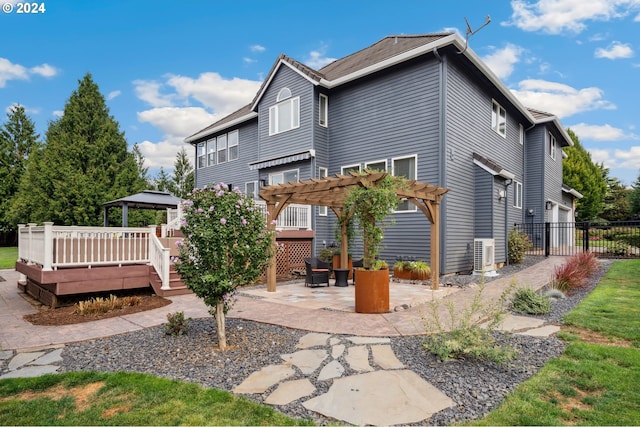 rear view of property with a gazebo, a deck, a pergola, and a patio