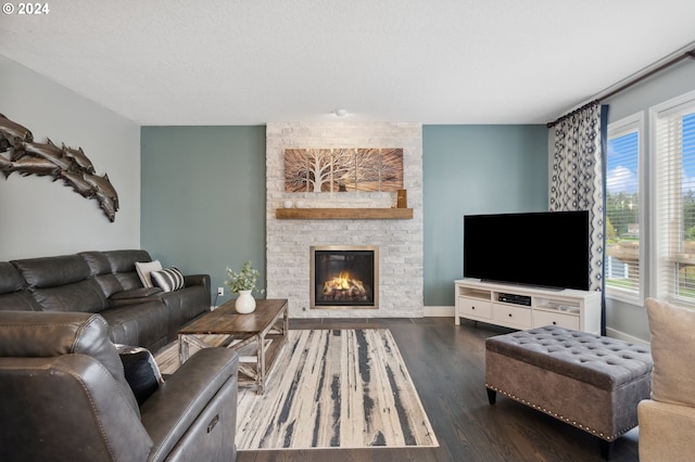 living room featuring a textured ceiling, a fireplace, and dark wood-type flooring