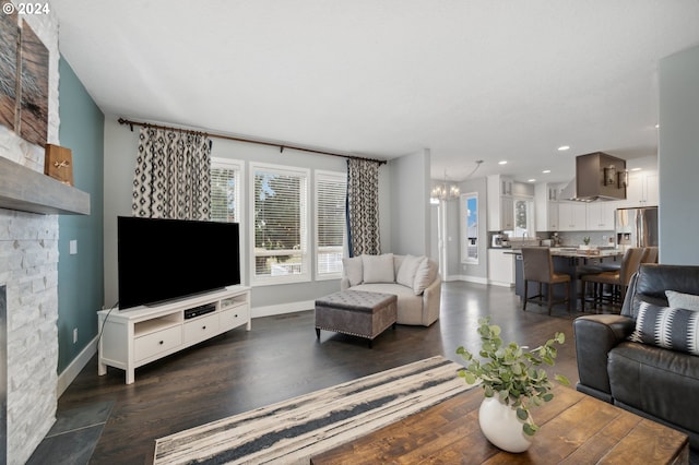 living room featuring a fireplace, dark wood-type flooring, and a notable chandelier