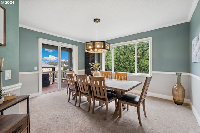 dining area with a textured ceiling, carpet floors, ornamental molding, and a notable chandelier