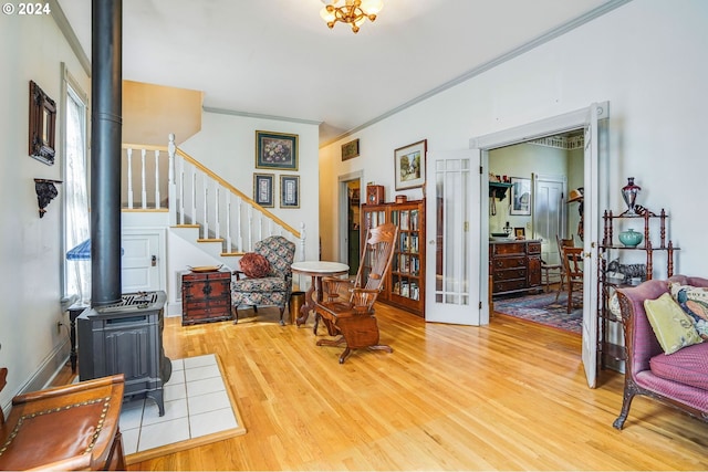 living room featuring ornamental molding, a wood stove, and light wood-type flooring