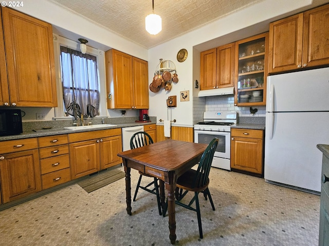 kitchen featuring a textured ceiling, sink, hanging light fixtures, backsplash, and white appliances