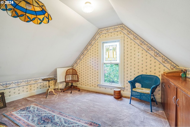 sitting room with carpet floors and vaulted ceiling