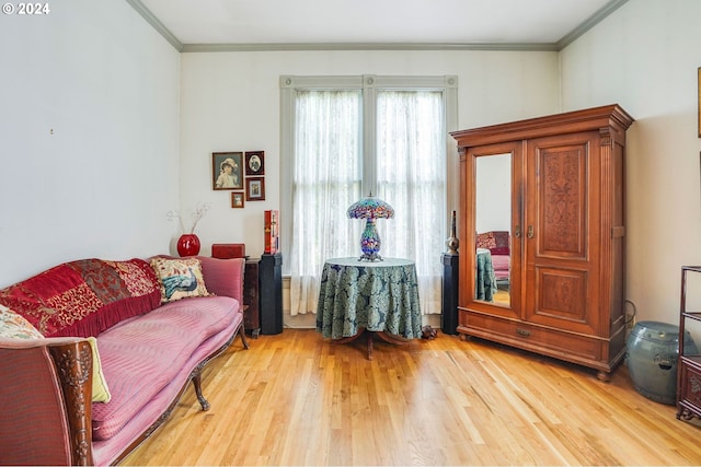 sitting room with light hardwood / wood-style flooring and crown molding