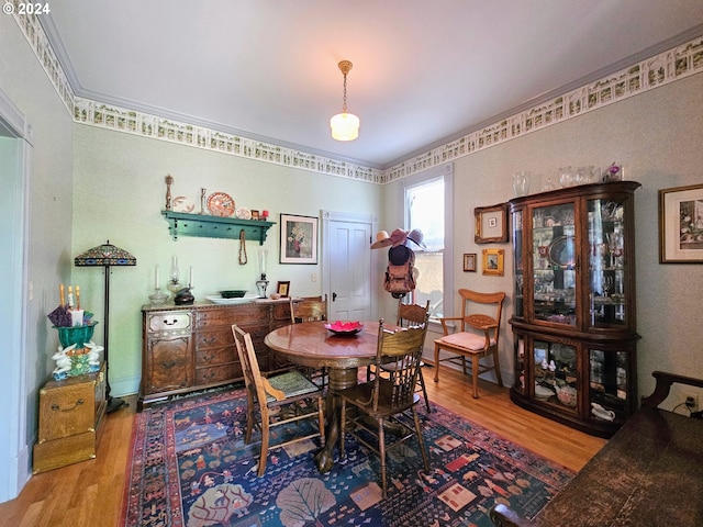 dining area with crown molding and hardwood / wood-style flooring