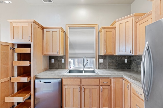 kitchen with appliances with stainless steel finishes, backsplash, light brown cabinetry, and sink