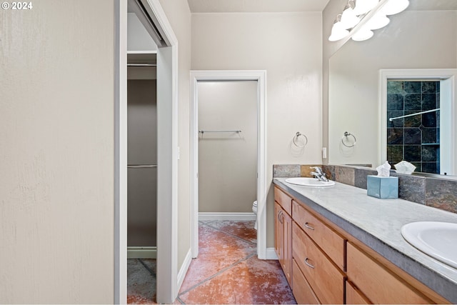 2721 La Darrah St, Eugene, OR 97404 - bathroom featuring double vanity, toilet, baseboards, and a walk in closet