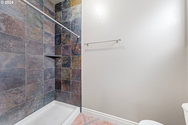 bathroom featuring tiled shower, tile patterned floors, and toilet