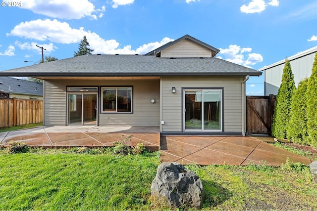 rear view of property with a lawn and a patio