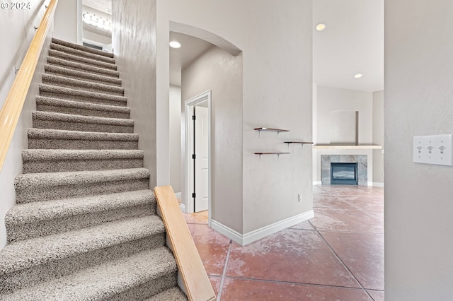 stairway featuring a tile fireplace