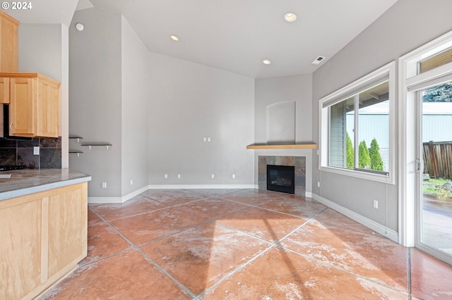 unfurnished living room featuring lofted ceiling and a fireplace