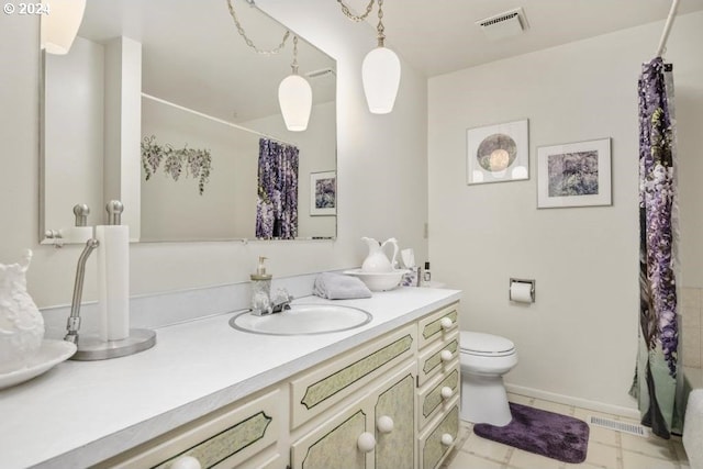 bathroom with tile patterned flooring, vanity, and toilet