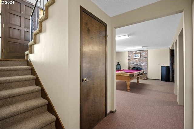 stairway featuring carpet, a textured ceiling, and pool table