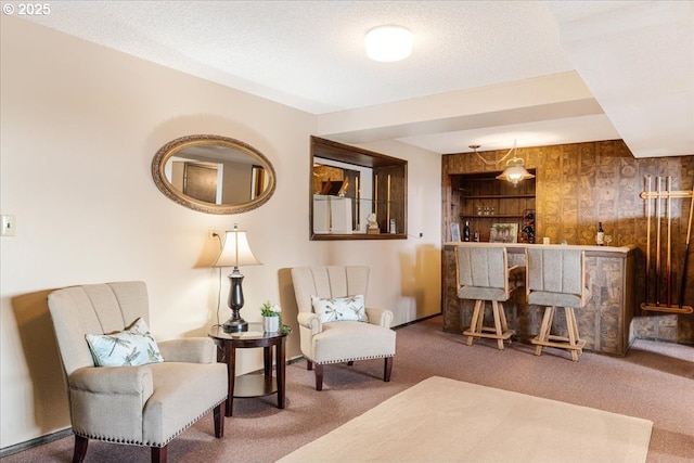 10685 Oak Dr SE, Salem, OR 97306 - living area with carpet flooring, a textured ceiling, wood walls, baseboards, and bar area