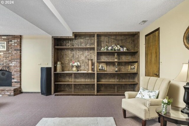 living room with built in features, carpet floors, and a textured ceiling