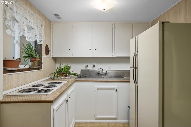 kitchen with white cabinetry and white appliances