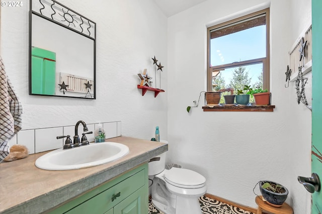 half bath featuring toilet, tasteful backsplash, and vanity