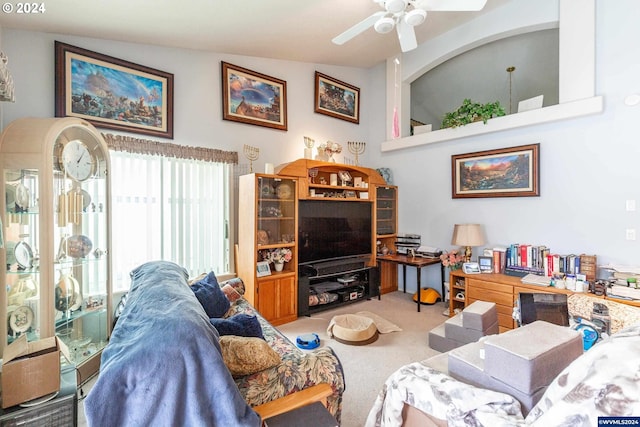 carpeted living room featuring ceiling fan and vaulted ceiling