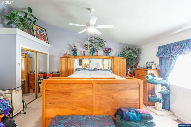 bedroom featuring light carpet, a textured ceiling, vaulted ceiling, ceiling fan, and a closet