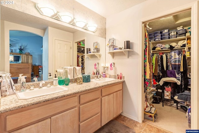 bathroom featuring tile patterned flooring, vanity, and a textured ceiling