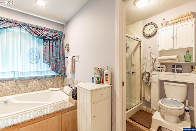 bathroom with separate shower and tub, toilet, and a textured ceiling