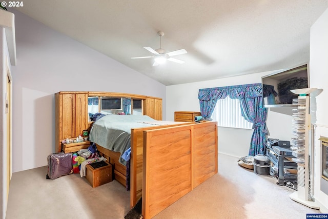 bedroom with ceiling fan, light colored carpet, and vaulted ceiling