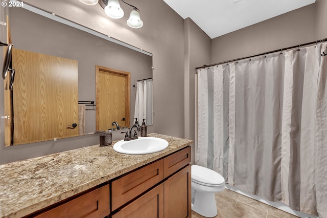 bathroom with vanity, toilet, and tile patterned flooring