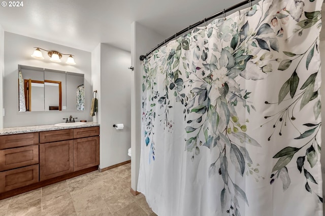 bathroom with vanity, curtained shower, and toilet